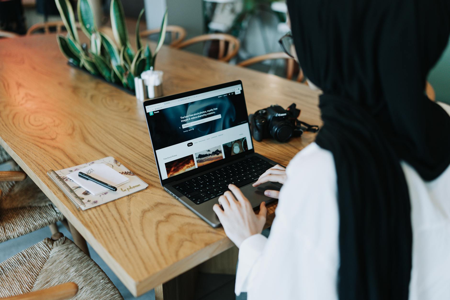 young woman sitting at the table and using a laptop